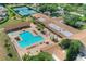 Aerial view showcasing a community pool, lounge chairs, clubhouse, and tennis courts, highlighting the neighborhood's amenities at 3124 Highlands Blvd, Palm Harbor, FL 34684