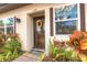 Charming front door with a colorful welcome mat, vibrant wreath, and beautiful landscaping at 3124 Highlands Blvd, Palm Harbor, FL 34684