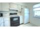 Clean kitchen with ample white cabinetry and black stove next to a white refrigerator at 3124 Highlands Blvd, Palm Harbor, FL 34684