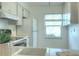 Kitchen featuring white cabinets, appliances, and a window with views of the exterior at 3124 Highlands Blvd, Palm Harbor, FL 34684