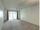 Spacious living room with neutral carpet, a ceiling fan, and a sliding glass door at 3124 Highlands Blvd, Palm Harbor, FL 34684