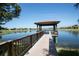 Serene lakeside gazebo with wooden deck and walkway, offering peaceful waterfront views at 314 Bluewater Falls Ct, Apollo Beach, FL 33572