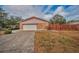 Brick home with a two-car garage and a modern privacy fence at 3201 Belmore Rd, Tampa, FL 33618