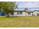 Rear view of the house showcasing a manicured lawn at 3334 Rock Valley Dr, Holiday, FL 34691