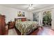 Main bedroom with leafy bedding, hardwood floors, and sliding glass doors leading to a patio at 3406 Waterbridge Dr, Tampa, FL 33618