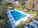 Aerial view of a community pool area with lounge chairs, trees, and a parking lot at 360 N Bayshore Blvd # 207, Clearwater, FL 33759