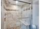 Walk-in shower featuring beautiful tile work, a built-in seat, and glass doors at 360 N Bayshore Blvd # 207, Clearwater, FL 33759