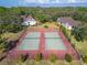 Aerial view of community tennis courts surrounded by trees, fences, and buildings at 360 N Bayshore Blvd # 207, Clearwater, FL 33759