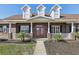 Inviting entryway with red double doors and a classic porch at 3717 Quail Nesting Pl, Plant City, FL 33565