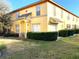 Two-story yellow house with manicured hedges and a grassy lawn at 3863 Island Way, St Petersburg, FL 33705