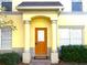 Orange front door accented by gray columns and landscaping at 3863 Island Way, St Petersburg, FL 33705