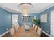 Elegant dining room featuring a large table, statement chandelier, and blue walls at 4811 Culbreath Isles Rd, Tampa, FL 33629