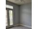 Bedroom featuring sleek gray walls, modern flooring, and natural light from the door with blinds at 501 Knights Run Ave # 1113, Tampa, FL 33602