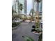 A paved driveway leading up to an entry gate with meticulously kept greenery, palm trees and high-rise apartments at 501 Knights Run Ave # 1113, Tampa, FL 33602