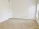 Bedroom featuring a window, tan carpet, and white door at 5010 Cactus Needle Ln, Wesley Chapel, FL 33544