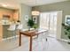 Bright dining room with a modern light fixture, dining table, and kitchen in background at 5010 Cactus Needle Ln, Wesley Chapel, FL 33544