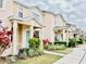 Row of townhomes with light beige exterior, landscaping, and teal doors at 5010 Cactus Needle Ln, Wesley Chapel, FL 33544