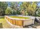 Above ground pool with wooden deck and surrounding greenery at 5043 Mockingbird Dr, Dade City, FL 33523