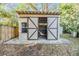 Tan colored storage shed with double doors in backyard at 5043 Mockingbird Dr, Dade City, FL 33523