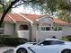 Tan condo with tile roof, landscaping, and a car parked in front at 562 Andorra Ne Cir # 562, St Petersburg, FL 33703