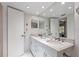 Double vanity bathroom with marble countertops and mirrors at 6085 Bahia Del Mar Blvd # 105, St Petersburg, FL 33715