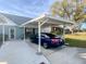 Carport with a blue sedan parked underneath, located in front of a light-blue house at 6103 Elmhurst Dr, New Port Richey, FL 34653