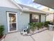 Front door entrance with landscaping and a light-blue brick exterior at 6103 Elmhurst Dr, New Port Richey, FL 34653