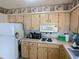 Kitchen area with white appliances and wood cabinets at 6103 Elmhurst Dr, New Port Richey, FL 34653