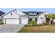 White farmhouse exterior with two-car garage and landscaped lawn at 6210 Nikki Ln, Odessa, FL 33556