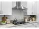 Stainless steel range hood and cooktop in a modern kitchen with granite countertops at 6210 Nikki Ln, Odessa, FL 33556