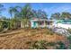 Cute bungalow with a teal door, landscaping, and a palm tree at 6327 Emerson S Ave, St Petersburg, FL 33707