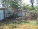 Overgrown backyard with a damaged tree and an old, rusty metal object at 6701 Hibiscus S Ave, South Pasadena, FL 33707