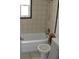 Bathroom with tiled walls, bathtub, and toilet at 6720 Hibiscus S Ave, South Pasadena, FL 33707