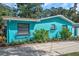 Charming teal house with landscaped yard and driveway at 717 Carolina Ave, Tarpon Springs, FL 34689