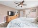 Spacious bedroom with a ceiling fan, large bed, and ample dresser storage at 7436 Baltusrol Dr, New Port Richey, FL 34654