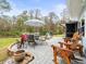 Relaxing patio with brick pavers, umbrella, table, chairs, and lush landscaping at 7436 Baltusrol Dr, New Port Richey, FL 34654