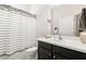 Bathroom with dark vanity, white toilet, and striped shower curtain at 7602 S Desoto St, Tampa, FL 33616