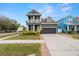 Two-story house with gray siding, yellow door, and landscaped front yard at 7602 S Desoto St, Tampa, FL 33616