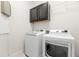 Laundry room with washer, dryer, and dark cabinets at 7602 S Desoto St, Tampa, FL 33616