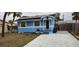 Front view of a light blue house with a paved driveway at 7623 Gulf Blvd, St Pete Beach, FL 33706