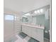 Modern bathroom with double vanity, glass block shower, and updated finishes at 8229 Eagles Park N Dr, St Petersburg, FL 33709