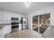 Well-lit kitchen featuring stainless steel appliances, white cabinetry, and screened lanai access at 8419 Quarter Horse Dr, Riverview, FL 33578