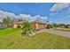 Exterior view of a single-story house with a palm tree and well-manicured lawn at 1123 Emerald Dunes Dr, Sun City Center, FL 33573