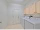 Laundry room with washer, dryer, and overhead cabinets at 1123 Emerald Dunes Dr, Sun City Center, FL 33573