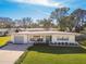 Single story home with attached garage and a large front yard at 11388 77Th Ave, Seminole, FL 33772