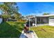 Backyard with large grassy area, screened patio, and fire pit at 11388 77Th Ave, Seminole, FL 33772