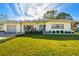 Updated mid-century modern home with a well-maintained lawn at 11388 77Th Ave, Seminole, FL 33772