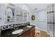 Bathroom featuring double sinks with dark granite countertops and decorative mosaic tiles at 1209 E Cumberland Ave # 505, Tampa, FL 33602