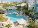 An aerial view of a large community pool surrounded by palm trees and lounge chairs at 1209 E Cumberland Ave # 505, Tampa, FL 33602