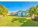 Large backyard with lush grass and tropical trees at 14042 Starboard Dr, Seminole, FL 33776